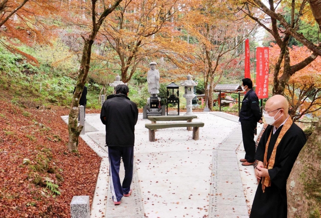 完成した石のプレートを１枚ずつ踏みしめ、「お砂踏み」する参拝客＝常瀧寺