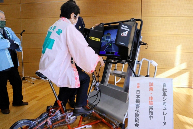 寄贈されたシミュレーターを体験試乗する出席者＝１１月２９日、丹波市春日町黒井、ハートフル春日
