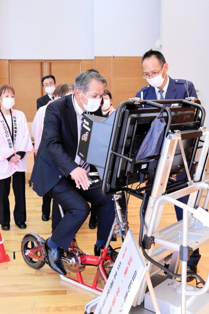 警察官から安全指導を受けながら、寄贈されたシミュレーターを体験試乗する出席者＝１１月２９日、丹波市春日町黒井、ハートフル春日