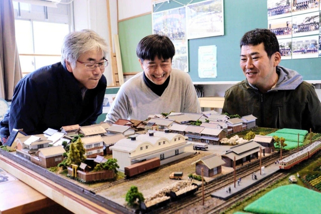 ５０年前の福住の町を再現したジオラマの完成を喜ぶ森田祥央さん（右）、西脇丈洋さん（中央）ら＝丹波篠山市福住