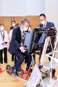警察官から安全指導を受けながら、寄贈されたシミュレーターを体験試乗する出席者＝１１月２９日、丹波市春日町黒井、ハートフル春日
