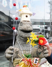 正月飾りを身につけた怪獣の石像＝丹波市氷上町横田