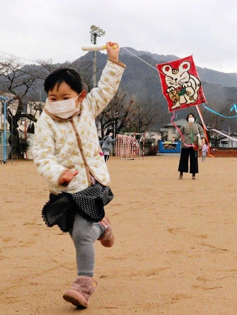 自作のたこを空に飛ばすため、全速力で走る子ども＝和田小学校