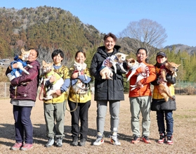 「アニマルレフュージ関西・篠山アーク」を訪問し、保護犬を抱く阪神タイガースの秋山拓巳投手（右から３人目）＝２０２２年１月１０日、丹波篠山市（球団提供）