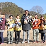 「アニマルレフュージ関西・篠山アーク」を訪問し、保護犬を抱く阪神タイガースの秋山拓巳投手（右から３人目）＝２０２２年１月１０日、丹波篠山市（球団提供）
