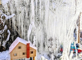 木の枝から垂れ下がる無数のつらら。樹下には小さな小屋の置物＝丹波篠山市