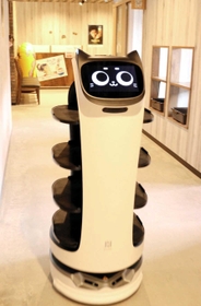 軽快な音楽を流しながら、配膳業務を担うネコ型ロボット「もぶにゃん」。田中さん夫妻は働きぶりに太鼓判を押す＝うりの郷