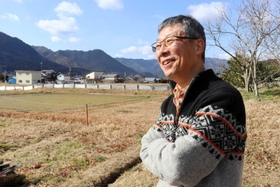「もくもく農園」などのサービス管理責任者を務める山本真義さん。左奥はこれから野菜を栽培する畑＝丹波市春日町下三井庄