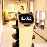 軽快な音楽を流しながら、配膳業務を担うネコ型ロボット「もぶにゃん」。田中さん夫妻は働きぶりに太鼓判を押す＝うりの郷