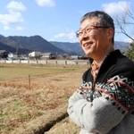 「もくもく農園」などのサービス管理責任者を務める山本真義さん。左奥はこれから野菜を栽培する畑＝丹波市春日町下三井庄
