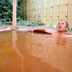 茶褐色の温泉につかり、リラックスする観光客＝「国領温泉　助七」