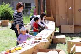 段ボールで作った秘密基地に絵を描く子どもたち＝芦田集学校