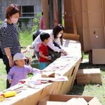 段ボールで作った秘密基地に絵を描く子どもたち＝芦田集学校