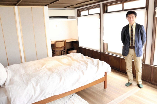 オーナーの小谷真巳さん。ウッド調で統一されたインテリアがおしゃれな寝室＝丹波篠山市北新町