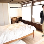オーナーの小谷真巳さん。ウッド調で統一されたインテリアがおしゃれな寝室＝丹波篠山市北新町