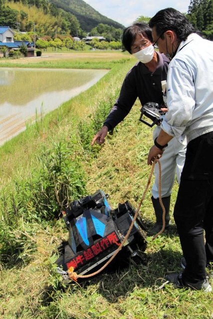 リモコン式の草刈り機の操縦を体験する農家＝丹波篠山市真南条上