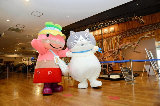 丹波竜のレプリカに圧倒されるマル（右）＝丹波市山南町谷川、丹波竜化石工房「ちーたんの館」