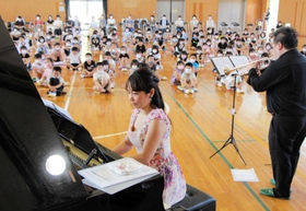 全校児童を前に演奏するピアニストの多川響子さんら＝６月２８日、北小学校