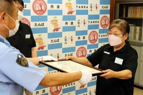 積極的な声かけで詐欺を防いだ西脇早苗さん（右）に、丹波署の長尾恭志署長から感謝状が贈られた＝丹波市柏原町柏原