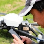 スマートフォンでドローンを飛ばす田んぼを選ぶ＝丹波篠山市小多田