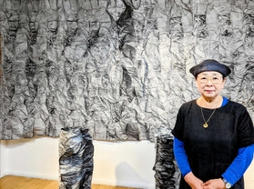 工房で、波打つような大作の前に立つ藤原さん。「墨と遊び戯れてきた」と語る＝丹波篠山市古市