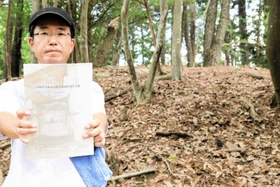 丹波市柏原地域の古墳の調査報告書を発行した東昭吾さん。奥は新たに発見した古墳時代中期のものとみられる「妻ヶ谷１号墳」＝丹波市柏原町南多田