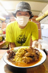 カレーを提供する店主の酒井克之さん。チキンカレーと豆カレーのあいがけ。色とりどりの副菜も盛りだくさん＝丹波市柏原町母坪