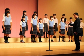 臼井真さんの指揮で歌う丹波市少年少女合唱団＝２８日、春日文化ホール