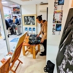 駅改札のすぐ横に設けられたブースでプレーするＤＪ。手前は公開制作で完成した切り絵アート＝ＪＲ篠山口駅