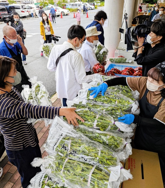 販売解禁となった黒枝豆を購入する人たち＝丹波篠山市東吹、味土里館