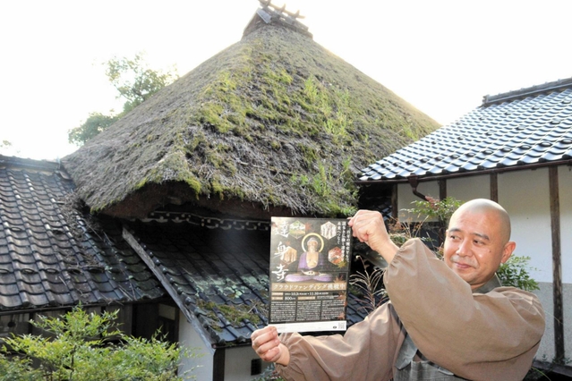 本堂のかやぶき屋根と渡辺正規住職。屋根には雑草が生い茂っている＝達身寺
