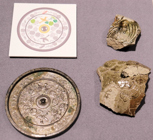 丹波焼の破片（右）と和鏡。どちらにも鳥と瓜の模様が刻まれている＝県立考古博物館