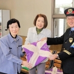 手編みの座布団を寄贈した矢村冬子さん（左）とＪＲ谷川駅の東村善夫駅長（右）ら＝ＪＲ谷川駅