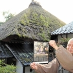 本堂のかやぶき屋根と渡辺正規住職。屋根には雑草が生い茂っている＝達身寺