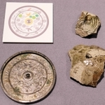 丹波焼の破片（右）と和鏡。どちらにも鳥と瓜の模様が刻まれている＝県立考古博物館