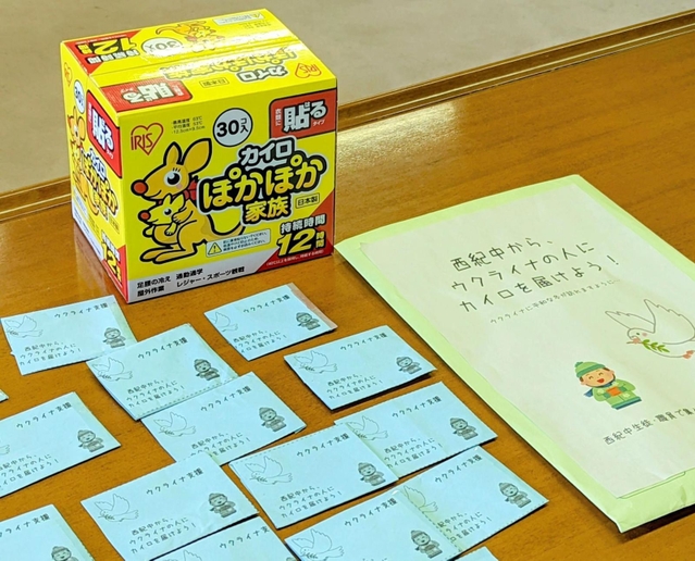 丹波篠山市立西紀中学校の生徒や教師から袋に入れて寄せられた寄付金と、購入する使い捨てカイロ＝丹波篠山市役所