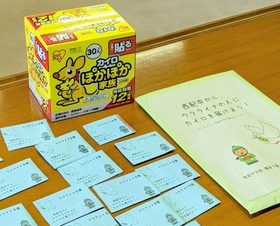 丹波篠山市立西紀中学校の生徒や教師から袋に入れて寄せられた寄付金と、購入する使い捨てカイロ＝丹波篠山市役所