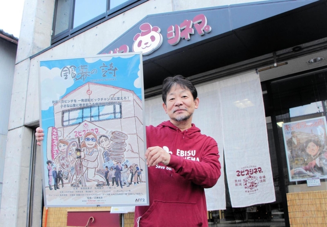 映画「銀幕の詩」のポスターを持って、上映をアピールする近兼拓史監督＝ヱビスシネマ。