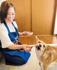自ら製造販売する鹿肉ジャーキーを、愛犬に与える森重希美さん＝丹波篠山市