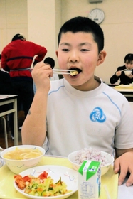 「山の芋とにんじんの紅白揚げ」を食べる児童＝多紀小学校