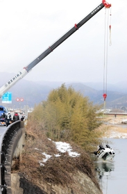 大型クレーンで引き揚げられる軽乗用車＝丹波市市島町勅使