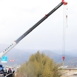 大型クレーンで引き揚げられる軽乗用車＝丹波市市島町勅使