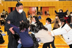 押し相撲で児童と触れ合う千代栄関＝春日部小学校