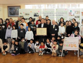 児童らと一緒に記念撮影する関係者たち＝南小学校