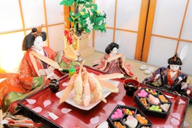 料理旅館「黒井屋」の名物「六角弁当」などを頬張ろうとする人形＝丹波市青垣町佐治