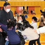 押し相撲で児童と触れ合う千代栄関＝春日部小学校