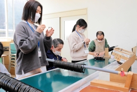 通所者と一緒に自動車部品を組み立てる武庫川女子大の学生＝丹波市柏原町柏原