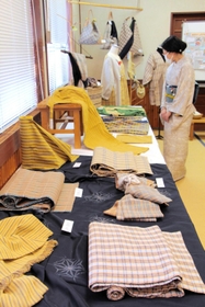 素朴な色合いの反物などが並ぶ会場＝丹波布伝承館