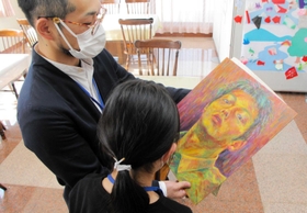 高校生の頃の作品を娘に見せる男性。「うまい。才能あると思う」と言われた＝植野記念美術館