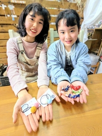 「くもべマルシェ」のキッズフリマで手作りのヘアゴムや箸置きを販売する川田彩夢さん（左）と山田茉穂さん＝里山工房くもべ
